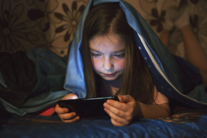 sweet-girl-browsing-smartphone-evening